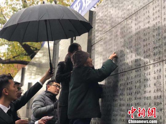 夏淑琴老人用手撫摸著親人的名字?！≈鞎苑f 攝