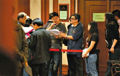 12日，北京麗都飯店，馬航工作人員叫乘客家屬進(jìn)屋領(lǐng)取慰問(wèn)金。目前，馬航兩次向乘客家屬發(fā)放慰問(wèn)金，但未啟動(dòng)賠償。新京報(bào)記者