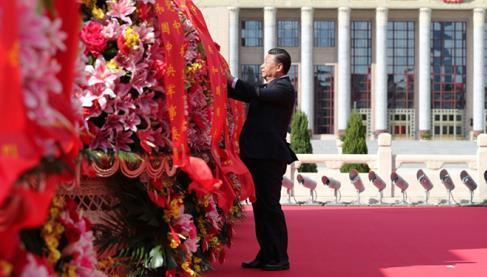 9月30日上午，習(xí)近平等黨和國(guó)家領(lǐng)導(dǎo)人來(lái)到北京天安門(mén)廣場(chǎng)，出席烈士紀(jì)念日向人民英雄敬獻(xiàn)花籃儀式。這是習(xí)近平整理花籃上的緞帶。圖片來(lái)源：新華社